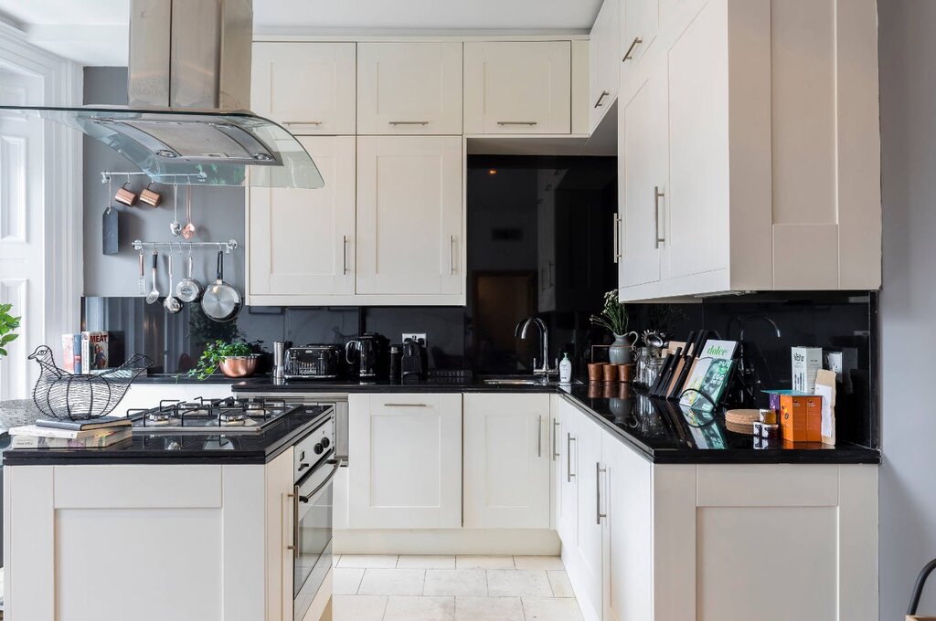 A white kitchen with a black stove