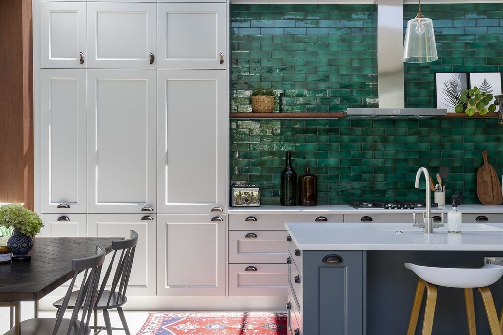 A white kitchen with green tiles