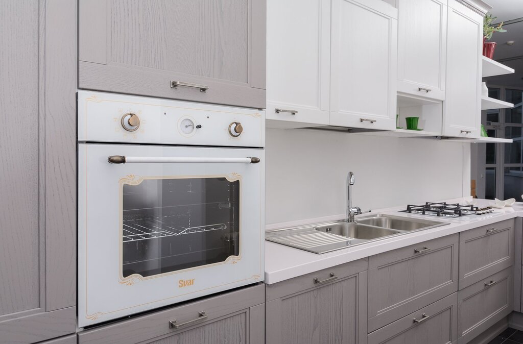 A black oven in a white kitchen