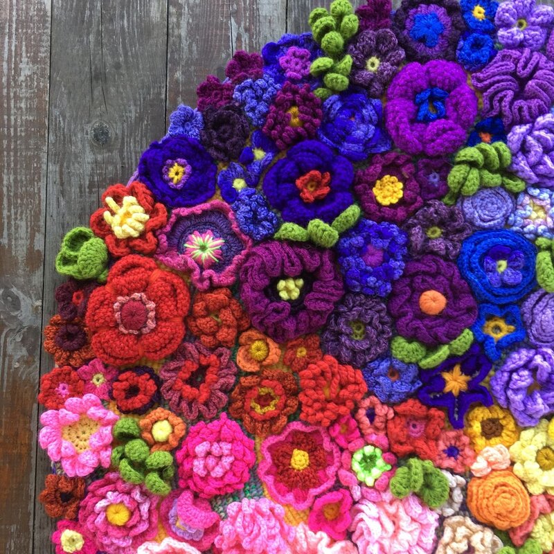 A rug made of knitted flowers