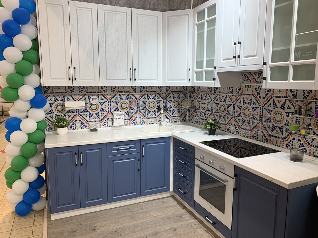 The kitchen has white upper cabinets and blue lower cabinets