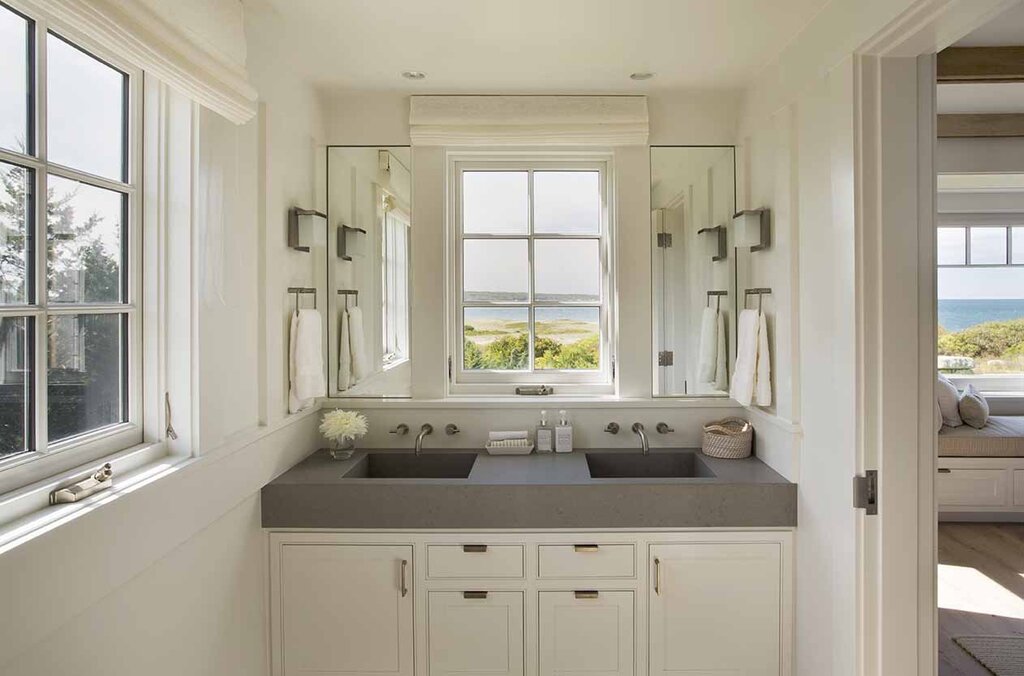 A sink under the window in the bathroom