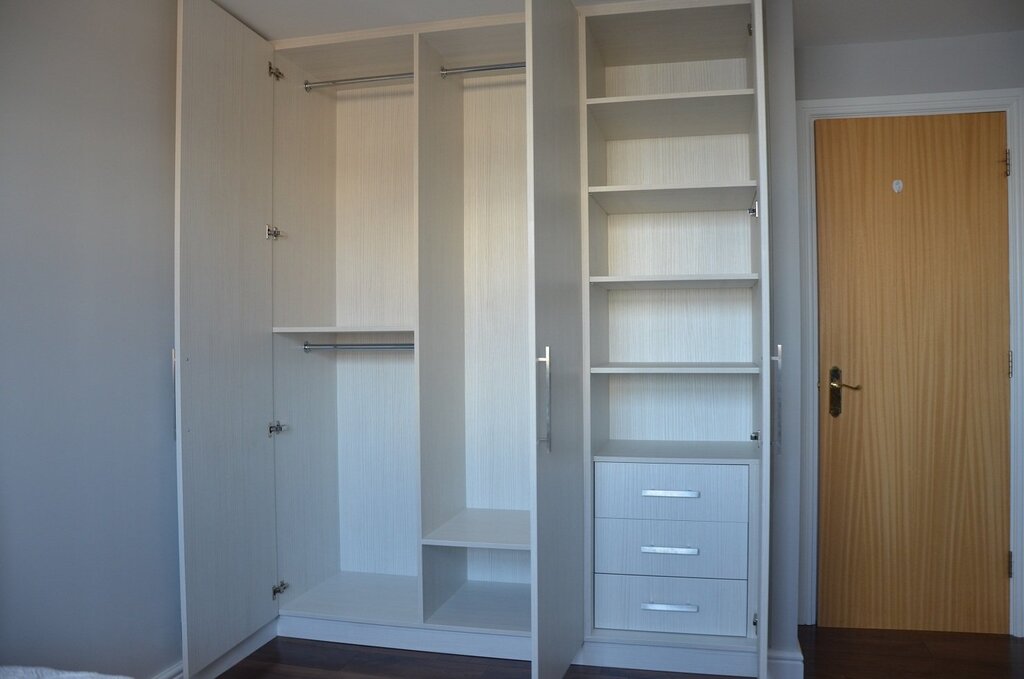 A cabinet in a niche with hinged doors