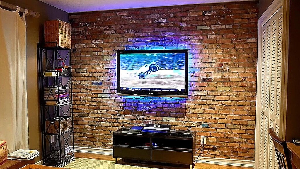 A television on a brick wall