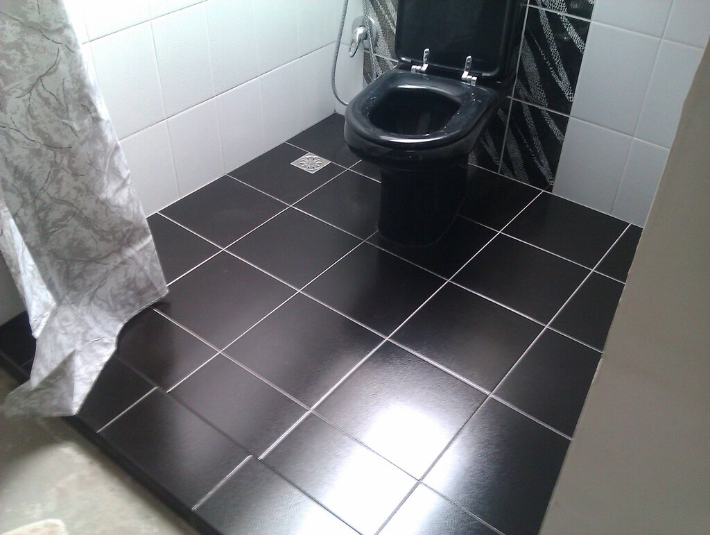 Laying tiles on the floor in the toilet